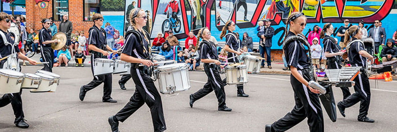 Band marching past a Hayward sign