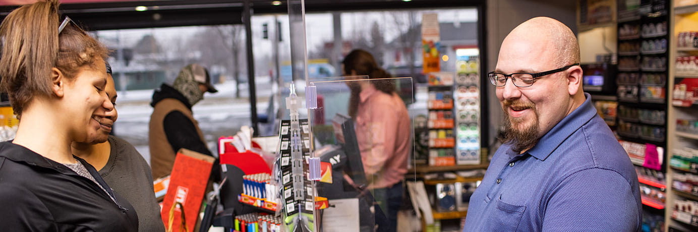 Customers paying a cashier at a Cenex Zip Trip convenience store