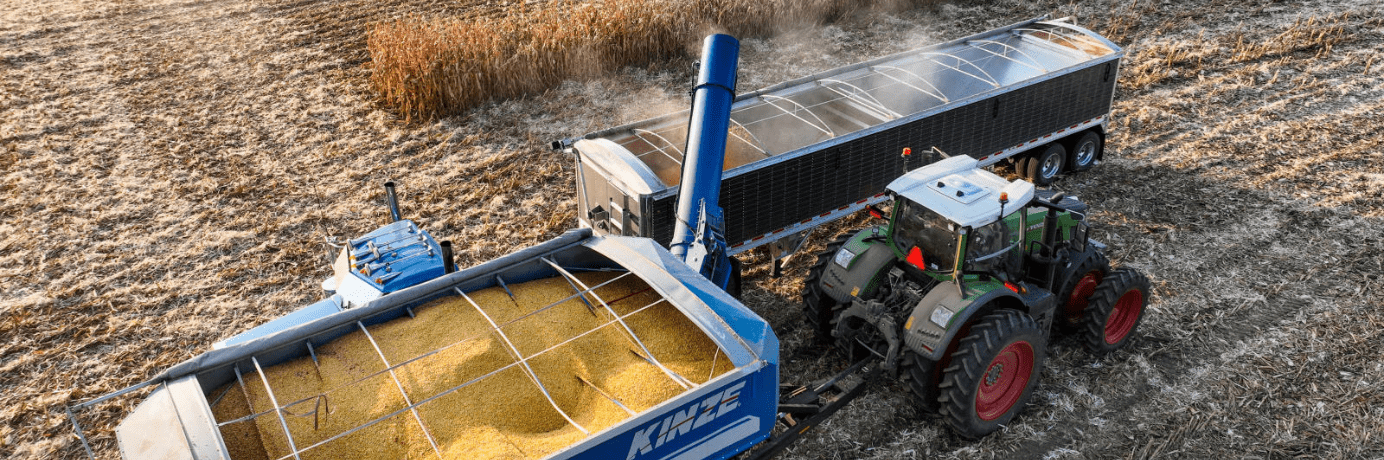 Corn harvest with combine unloading into a grain trailer.
