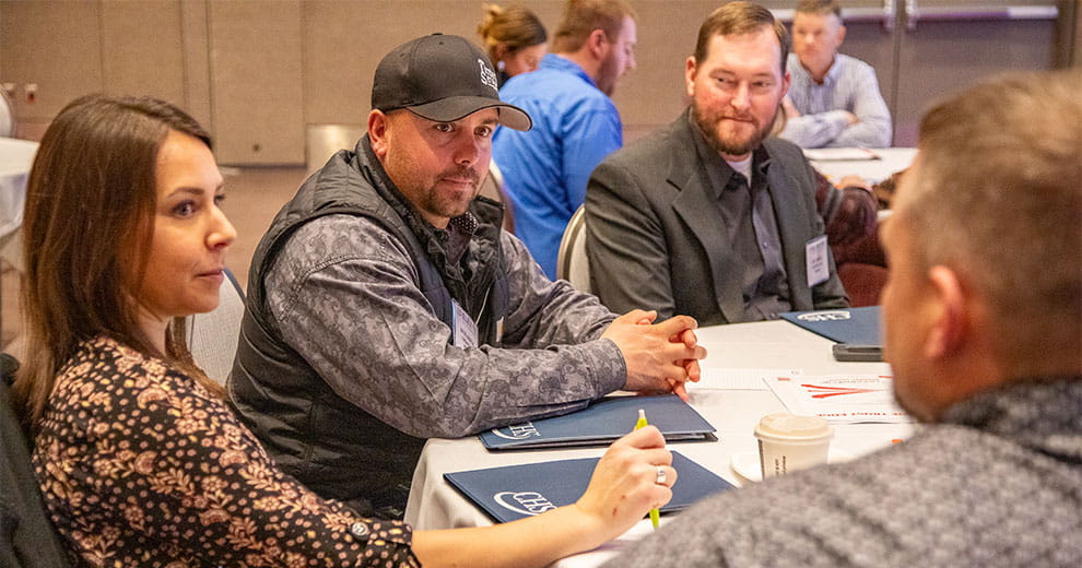 A group of young men and women sitting at a table