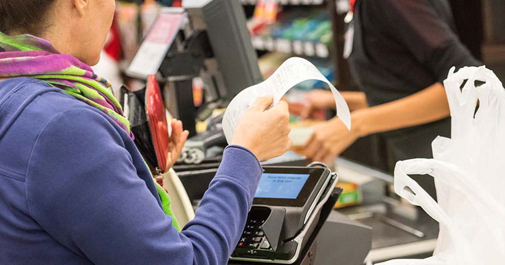 Woman holding receipt by credit card reader