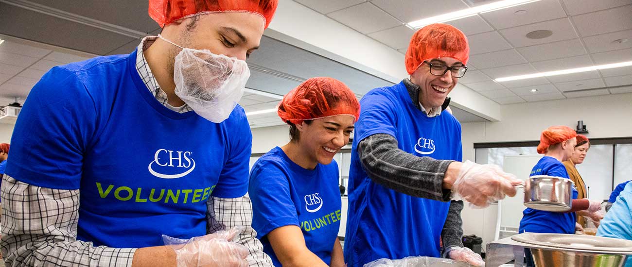 CHS volunteers smiling and packing meals