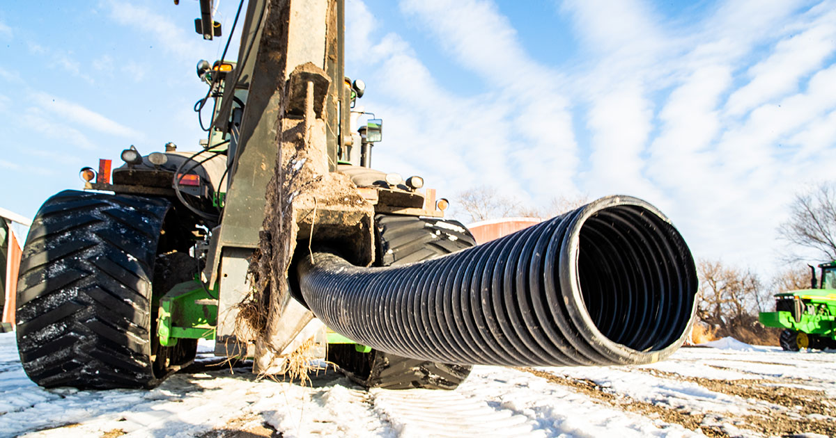 Broden Farms tractor moving pipe on field