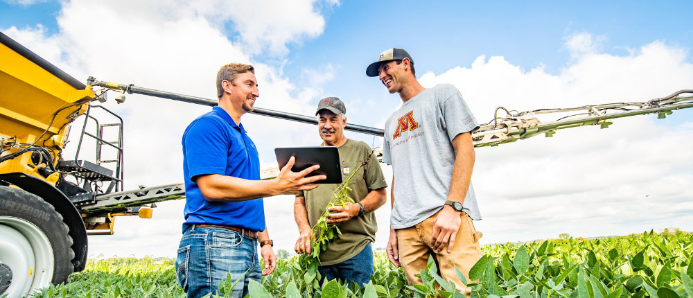 agronomists talking with grower in field