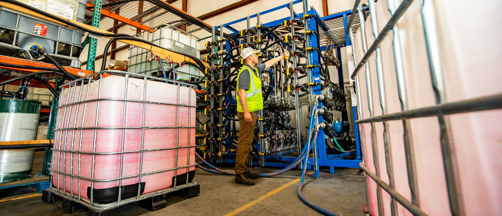 employee in warehouse next to IBC tote