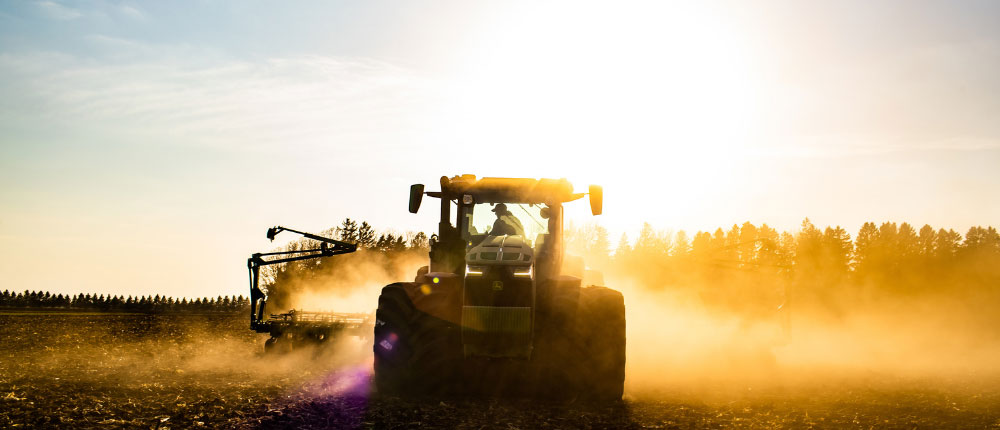 Harvesting a field at sunset