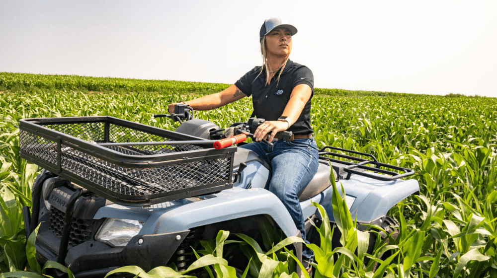 Woman driving a four-wheeler in a crop field