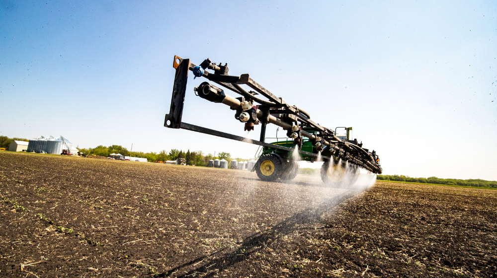 A sprayer applying chemicals in a field