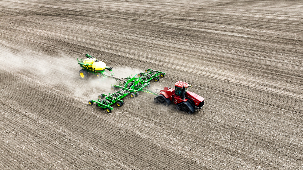 Tractor pulling planter across a field