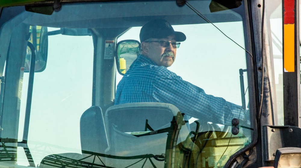 Man looking back while driving a tractor