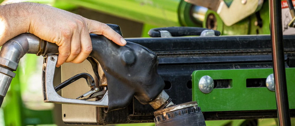 A farmer puts biodiesel fuel in a tractor’s fuel tank.