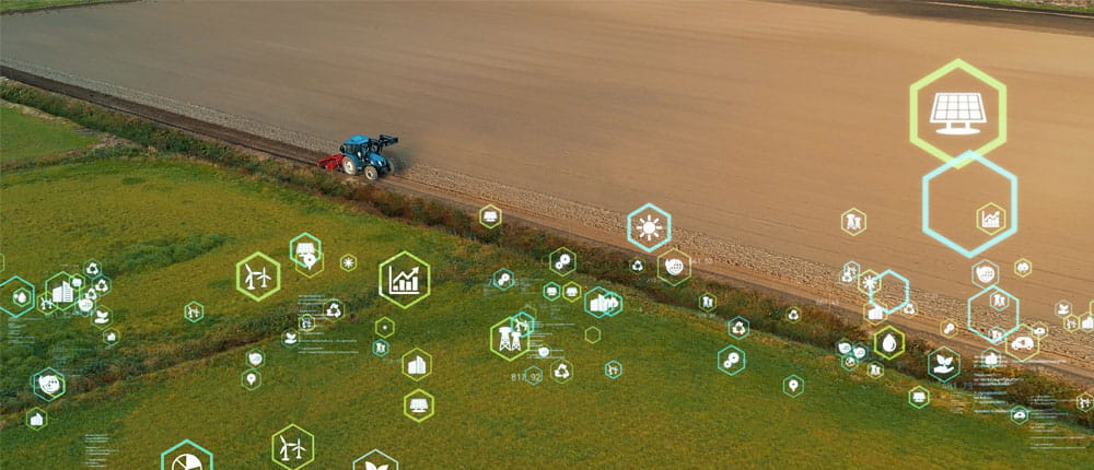 Aerial photo of a tractor driving down road next to a soybean field with artistic hexagonal symbols with ag tech icons inside. 