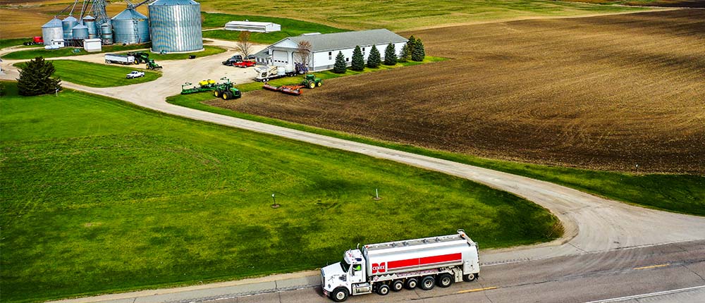 A Cenex branded truck delivers fuel to a farm.