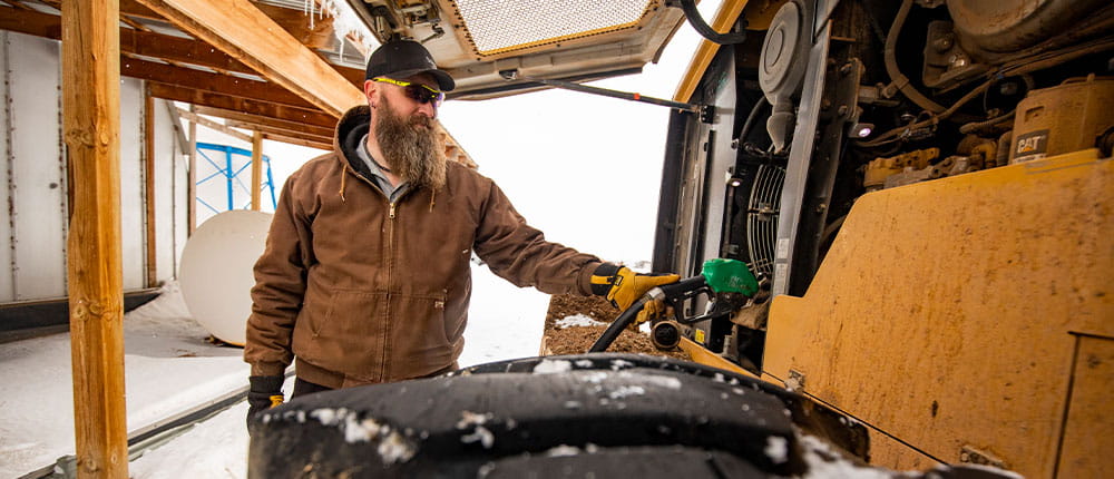 Farmer Joe Ridl putting diesel fuel in a piece of machinery.