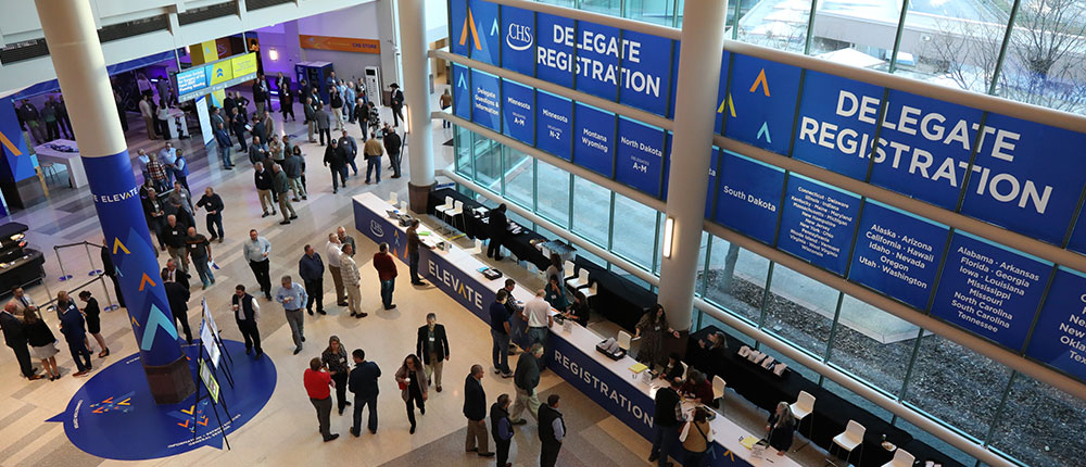 Attendees talking to each other in small groups in the convention center lobby