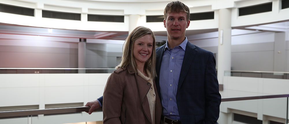 Man and woman posing for a portrait inside convention center