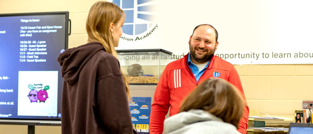 A teacher talking to two students