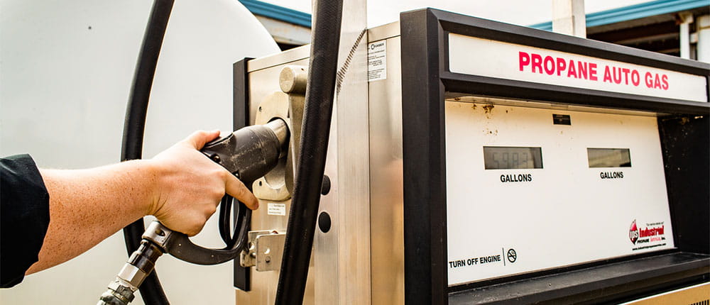 A view of someone’s hand pumping propane auto gas