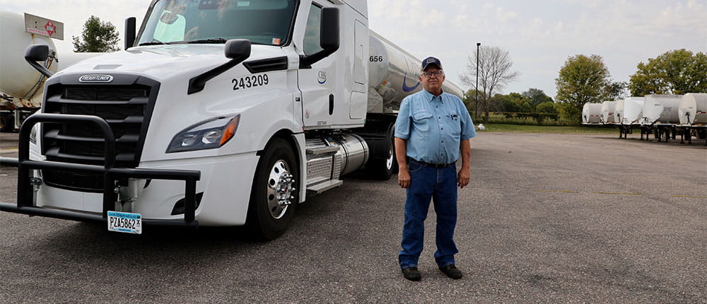 Man stands near a CHS tanker truck in a parking lot