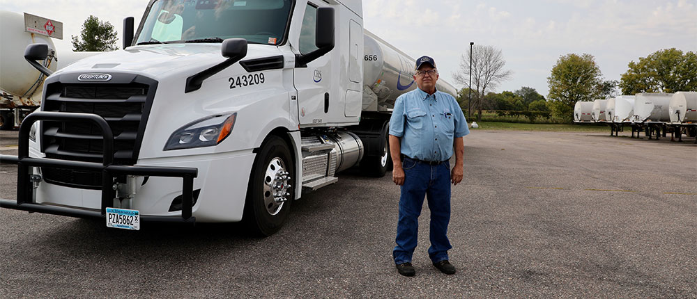 Man stands near a CHS tanker truck in a parking lot