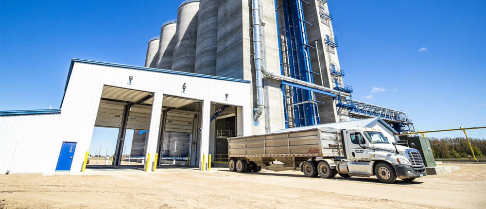 A grain elevator with a delivery truck.
