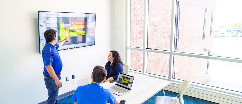 SDSU precision ag instructor Nic Uilk, left, examines field maps with students Park Aase, center, and Rosalyn Madsen in one of the new Raven Precision Agriculture Center's high-tech classrooms.
