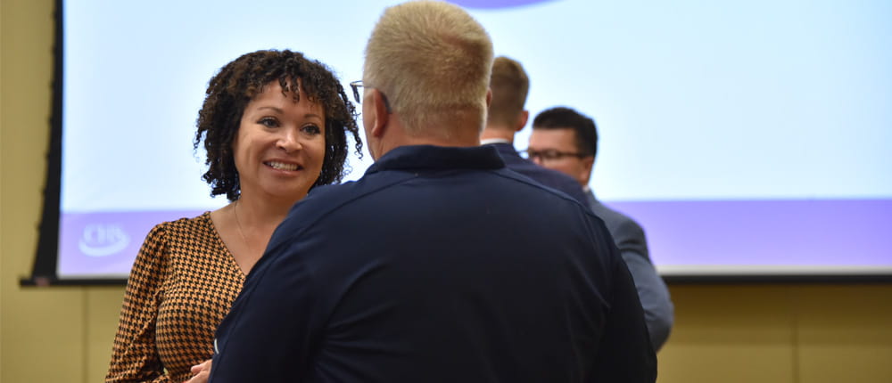 Megan Rock from CHS speaking with a CHS owner at a 2022 owners forum.  