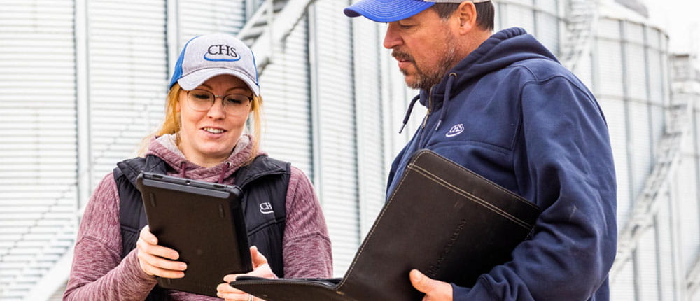 a man and woman look at a tablet