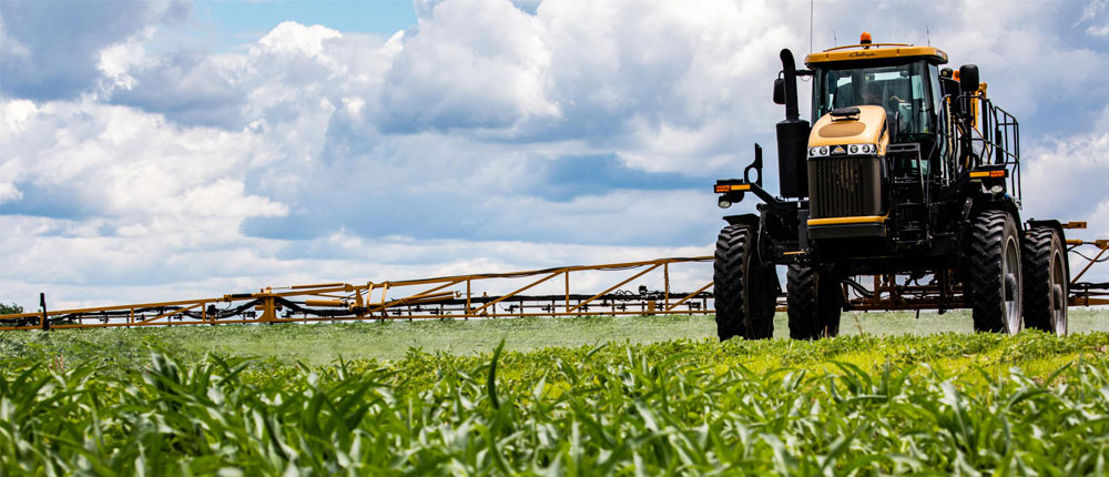 Tractor applying crop protection in a field of corn