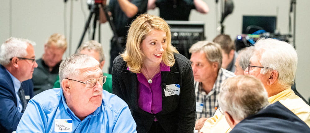 Owners seated at a table talking with a CHS executive