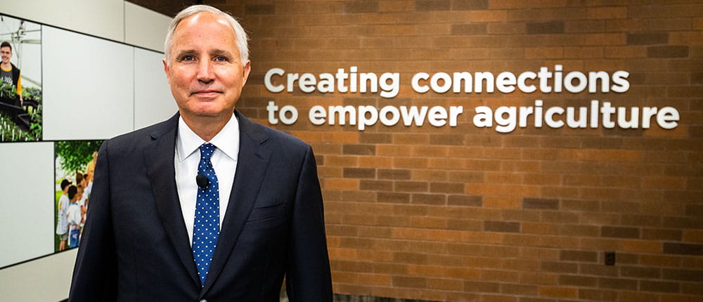 Jay Debertin in front of a sign spelling out Creating connections to empower agriculture