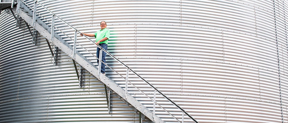 Man on stairs on side of grain bin