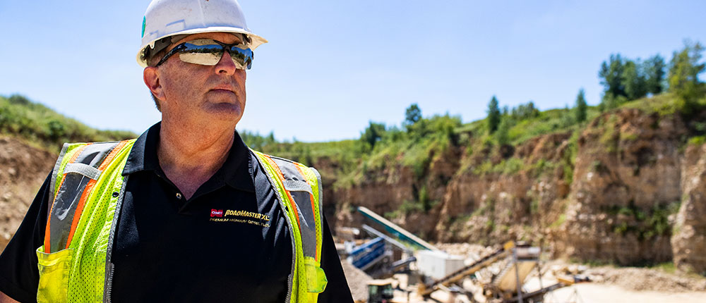 Man in hard hat in front of quarry