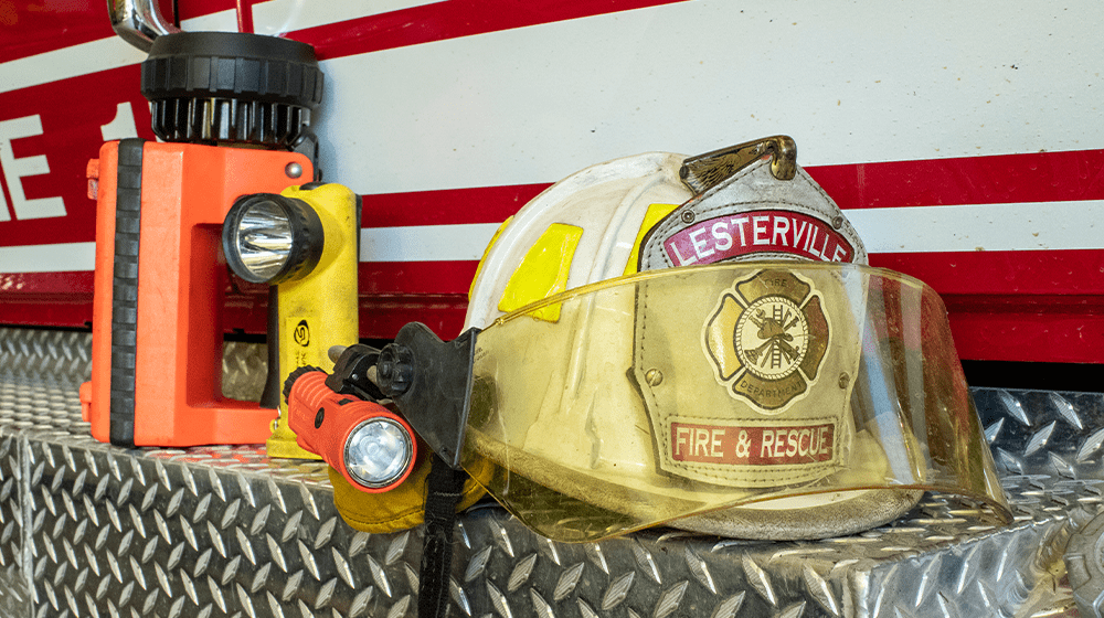 Fire hat and flashlight sitting on back of fire truck