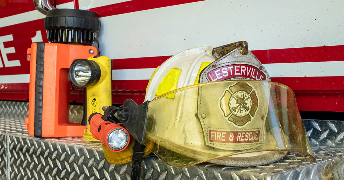 Fire hat and flashlight sitting on back of fire truck