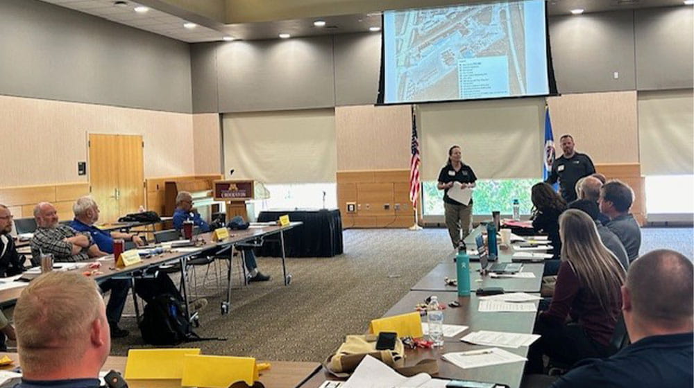 man and woman presenting in front of group of people