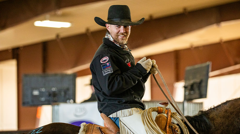 Man sitting on horse with reins in hand