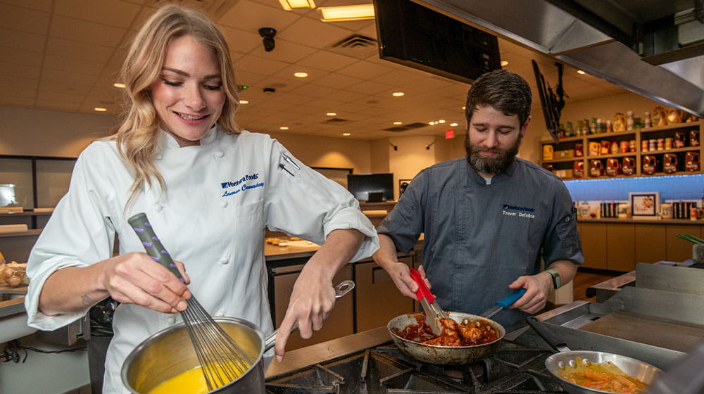 A woman and man testing recipes in a test kitchen