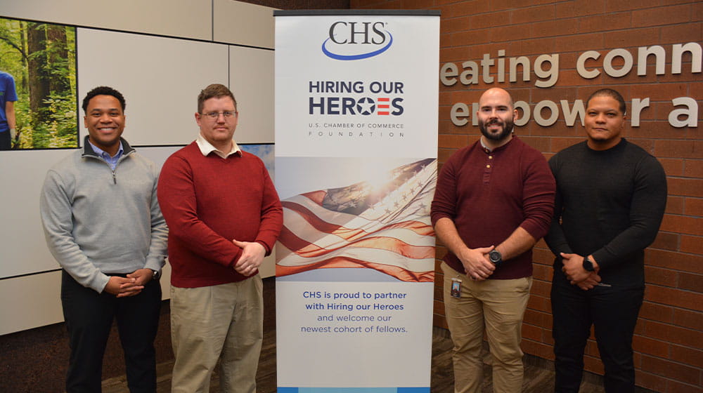 Four men standing by sign
