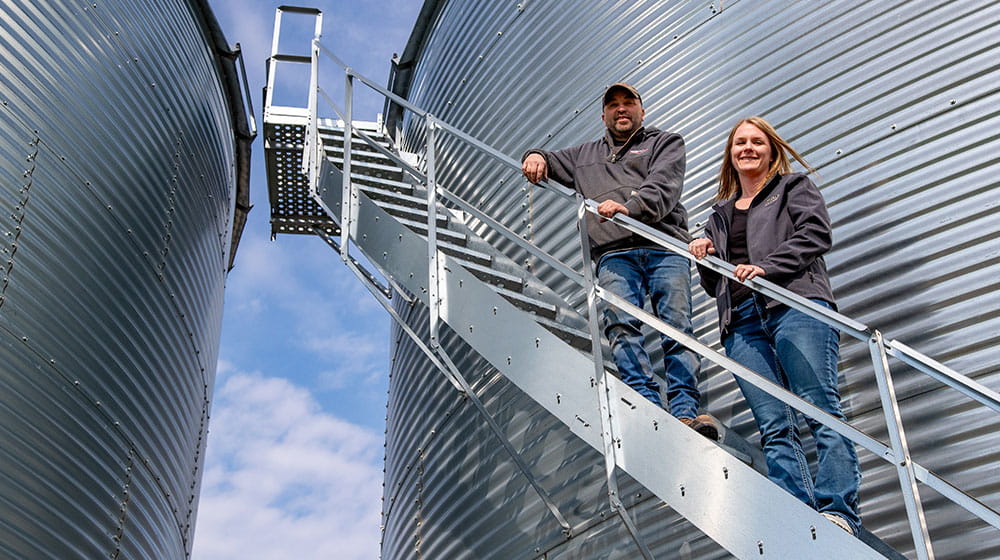 Man and woman on grain bin stairs