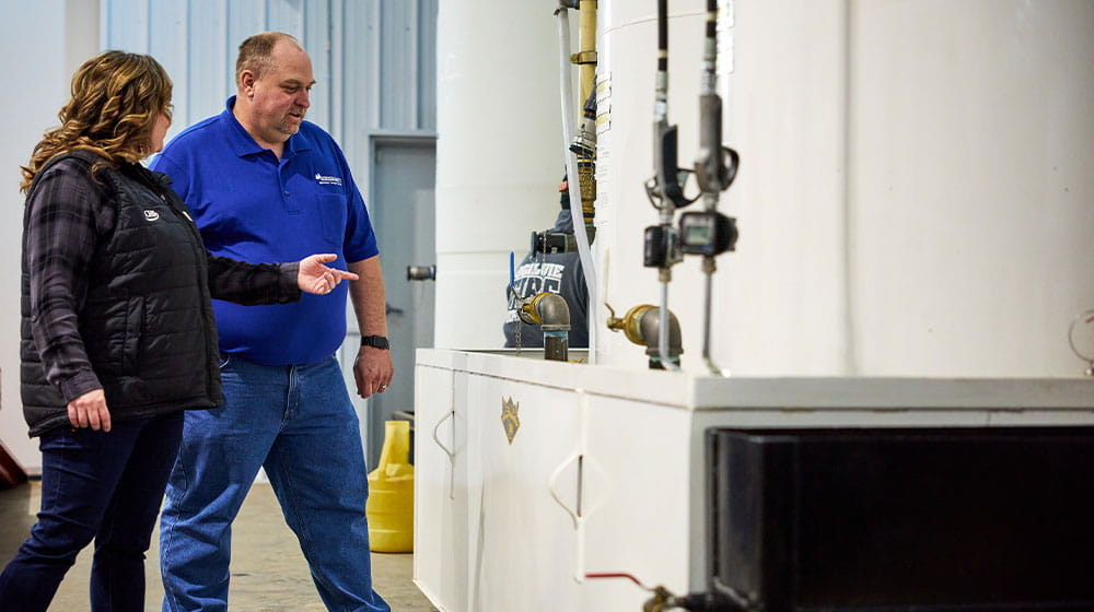 Woman and man looking towards a bulk tank