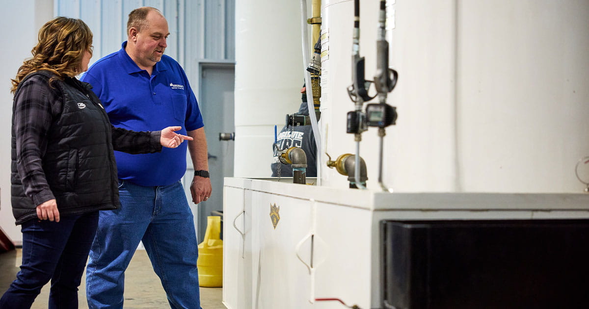Woman and man looking towards a bulk tank