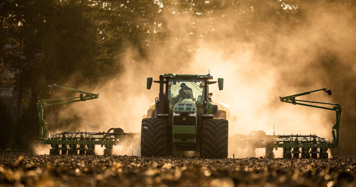 A tractor and planter in a field.