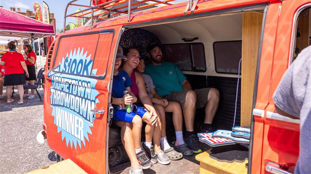 Family sitting inside the Hometown Throwdown van