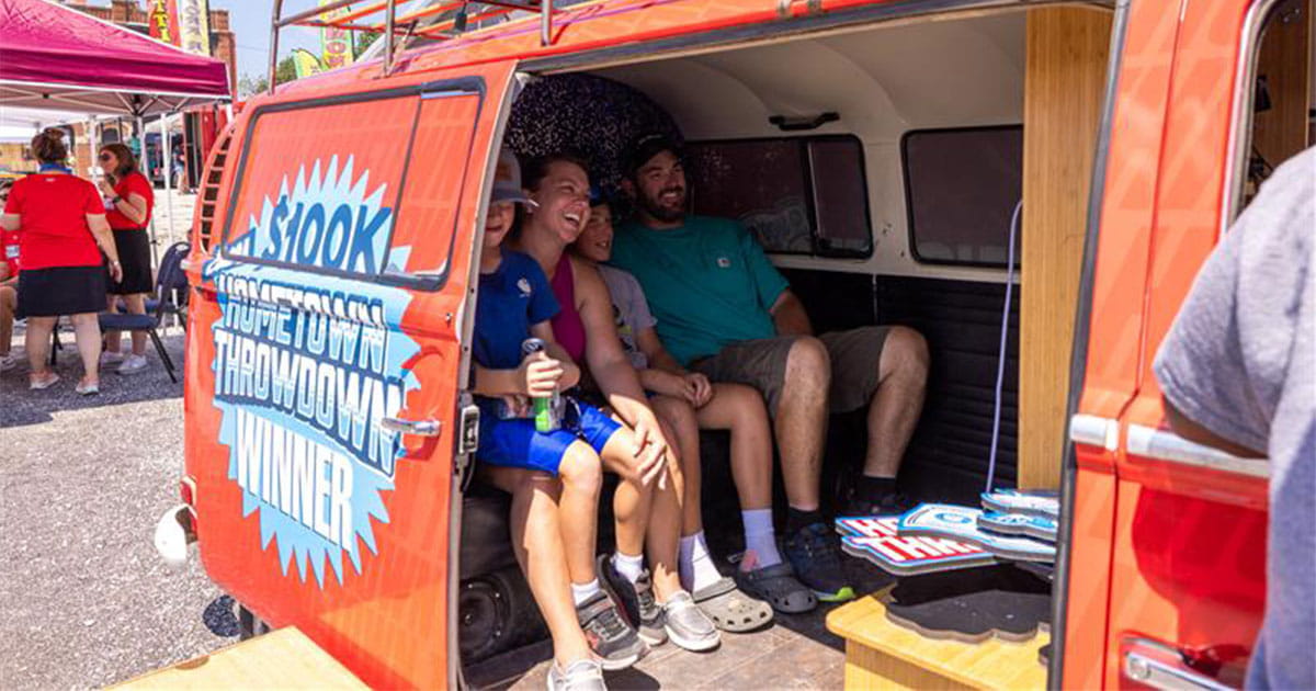 Family sitting inside the Hometown Throwdown van