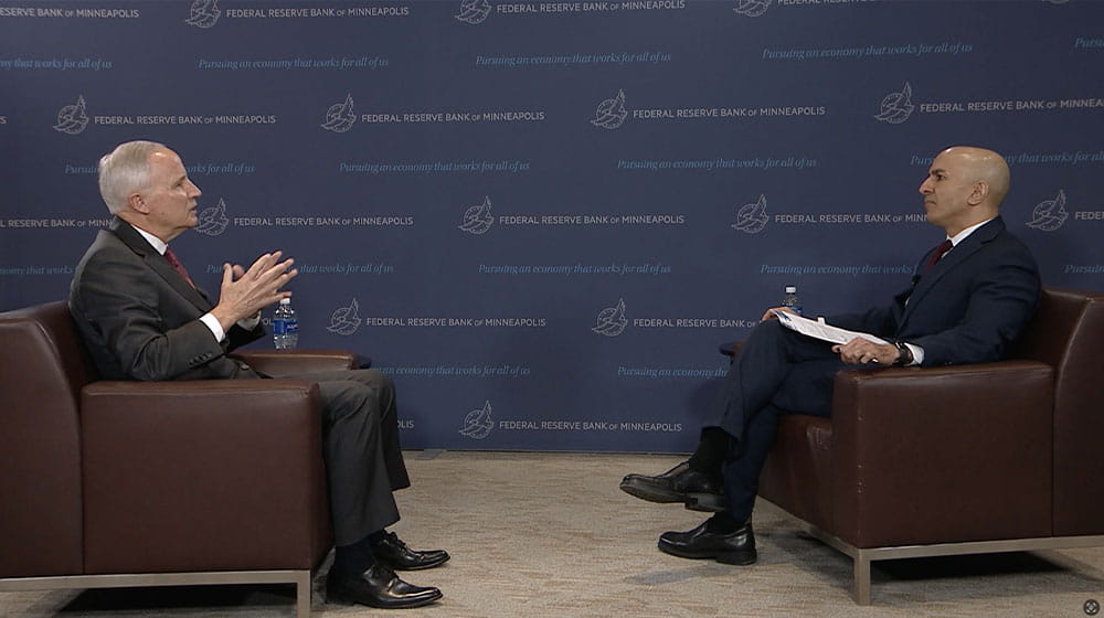 Two men sitting in chairs facing one another