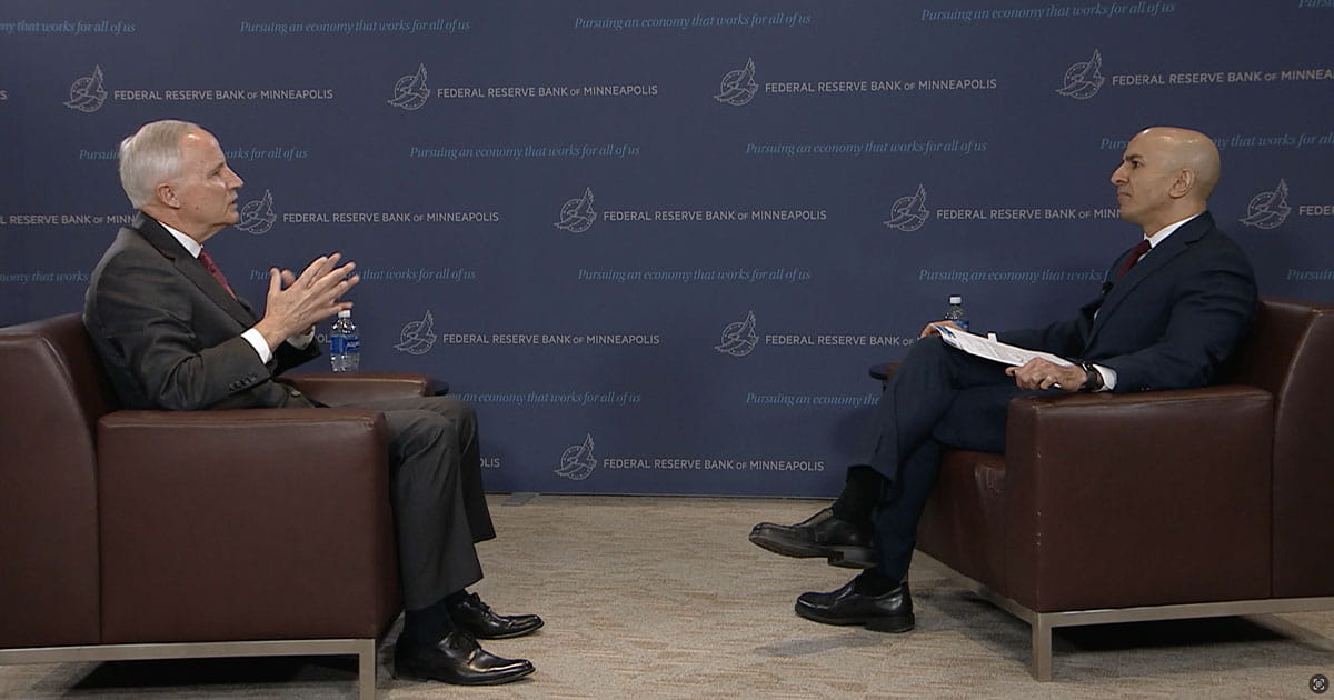 Two men sitting in chairs facing one another