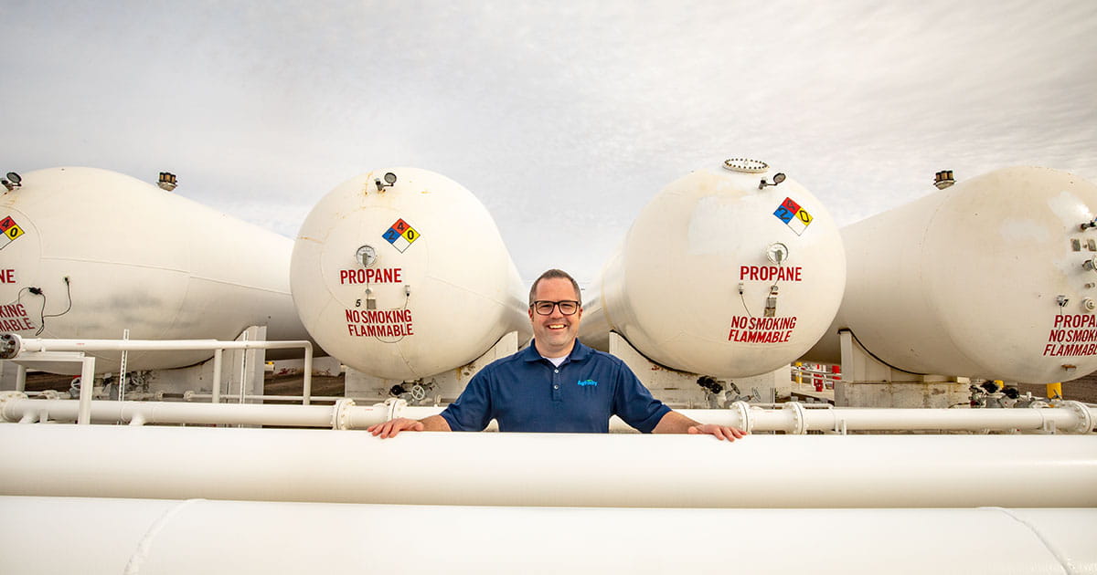 Man standing by propane tank.
