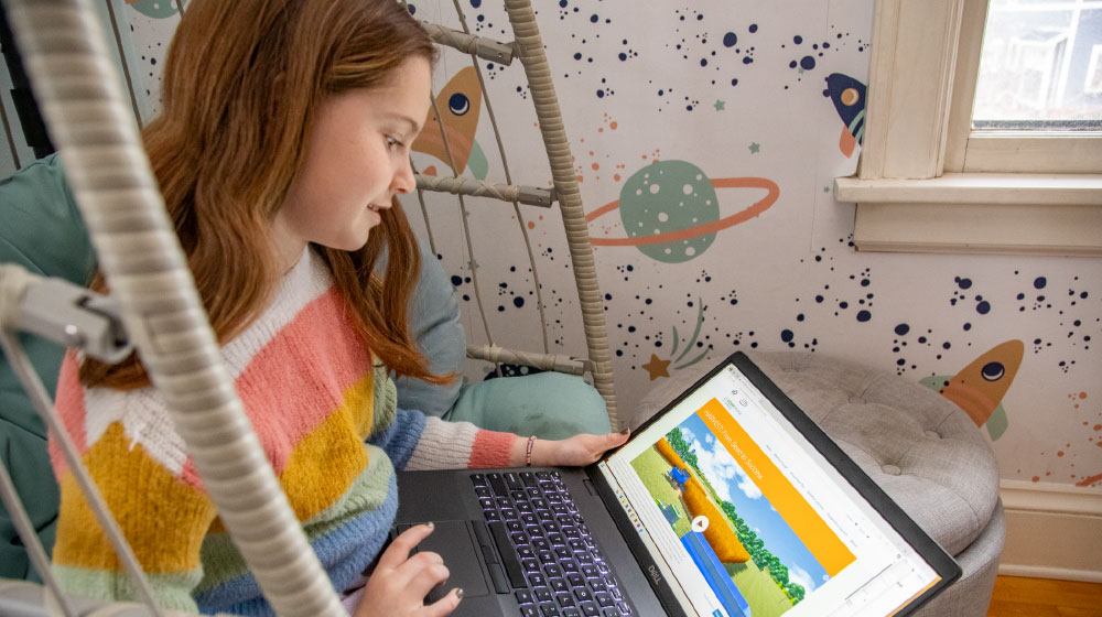 Child playing interactive farming game on laptop
