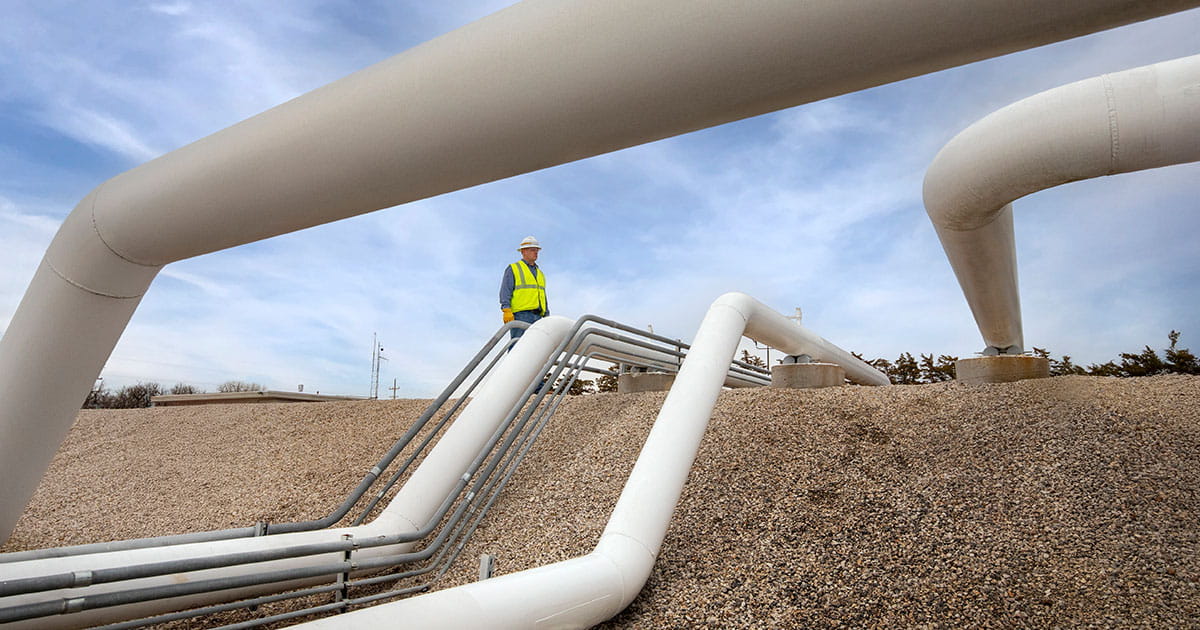 Man standing by pipes.